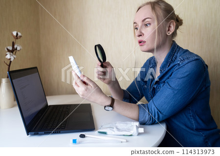 Toothpaste ingredients. Girl at laptop checks composition of toothpaste and is surprised by dangerous composition of product. Emulsifiers, preservatives, dyes, PEG, SLS, parabens, diethanolamine Toothpaste ingredients. Girl at laptop checks composition of toothpaste and is surprised by dangerous composition of product. Emulsifiers, preservatives, dyes, PEG, SLS, parabens, diethanolamine 114313973