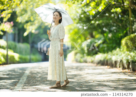 拿著遮陽傘的一個少婦 拿著遮陽傘的一個少婦 114314270