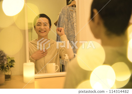 Middle-aged woman doing night skin care Middle-aged woman doing night skin care 114314482