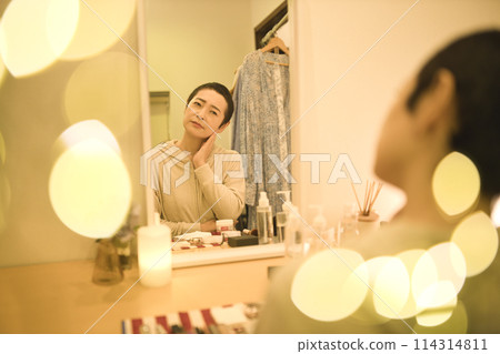 A middle-aged woman who does her nighttime skin care routine while worrying about rough skin 114314811