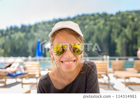 Young teenage girl having fun with her family on a beach vacation 114314981