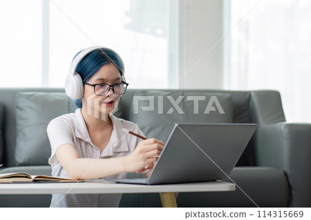 Smiling girl student wear headphone study online with teacher, happy young asian woman learn lecture watch webinar write notes look at laptop sit in home, distant education Smiling girl student wear headphone study online with teacher, happy young asian woman learn lecture watch webinar write notes look at laptop sit in home, distant education 114315669