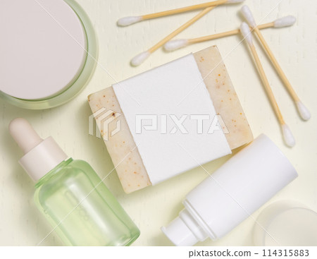 Soap bar with blank label near cosmetic products on light yellow top view, mockup Soap bar with blank label near cosmetic products on light yellow top view, mockup 114315883