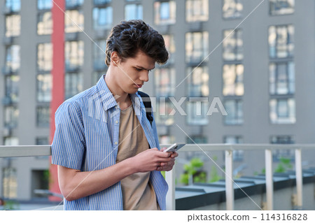 Relaxed handsome young male with smartphone, urban outdoor Relaxed handsome young male with smartphone, urban outdoor 114316828