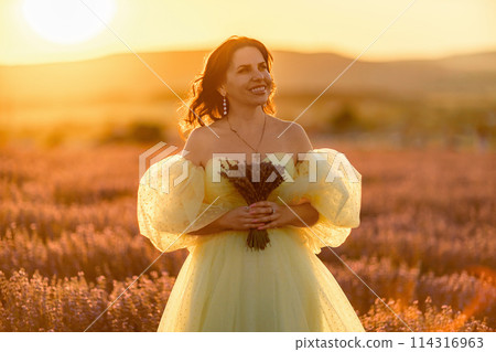 Woman lavender field. happy woman in yellow dress in lavender field summer time at sunset. Aromatherapy concept, lavender oil, photo session in lavender Woman lavender field. happy woman in yellow dress in lavender field summer time at sunset. Aromatherapy concept, lavender oil, photo session in lavender 114316963