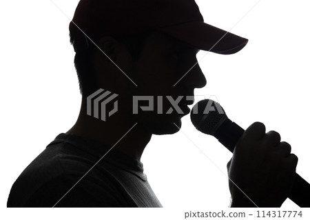 Young man in cap singing into a microphone 114317774