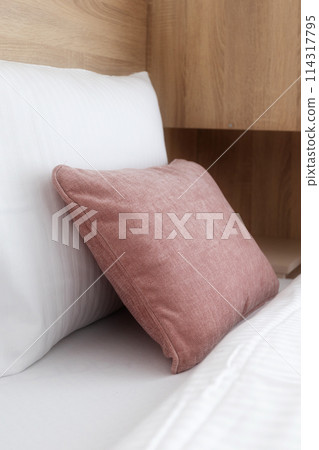 Pink and white soft pillows on the bed 114317795