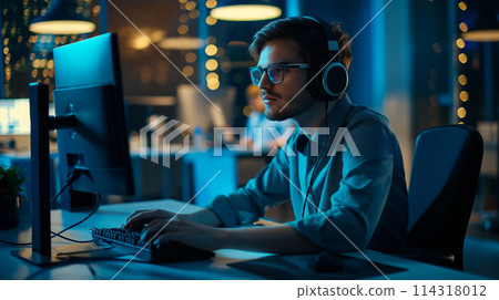 Man With Headphones Using Computer 114318012