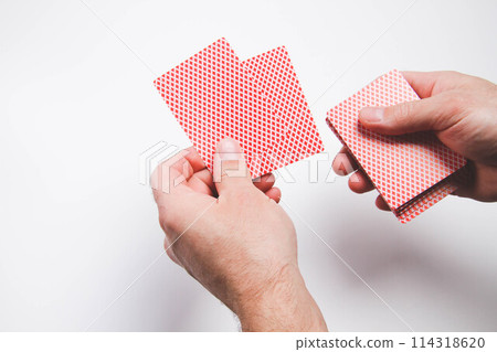 A deck of playing cards in hand. The player deals cards. Poker game. 114318620
