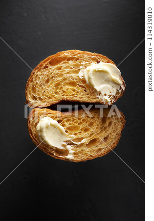 Doble Cross section of a croissant with butter on black background, copy space Doble Cross section of a croissant with butter on black background, copy space 114319010