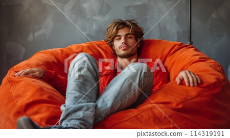 Young Man Sitting on a Bean Bag Chair 114319191