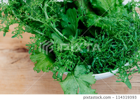 Green fresh mix lettuce salad leaves in white bowl. 114319393