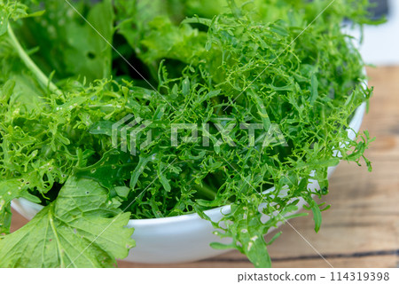 Green fresh mix lettuce salad leaves in white bowl. 114319398