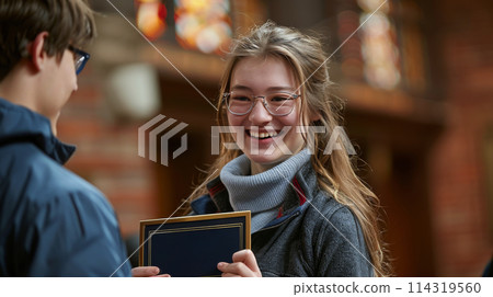 Young Woman Holding Plaque in Front of Man 114319560