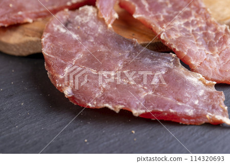 dried pork meat with spices and salt on the table 114320693
