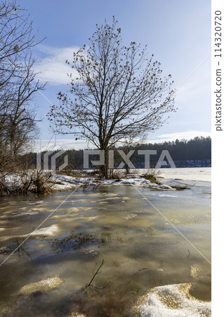 the ice-covered surface of the river in the winter season the ice-covered surface of the river in the winter season 114320720