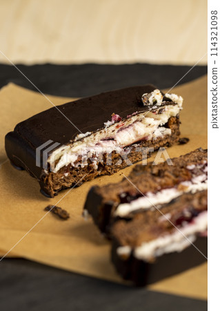 cottage cheese dessert with cherry jam covered with chocolate 114321098