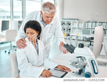 This is so inappropriate. a young scientist looking uncomfortable while being touched on her shoulder by a senior scientist in a lab. 114322109