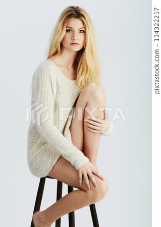 Woman, portrait and fashion on chair in studio for confidence style on white background, relaxing or casual. Female person, model and face or sitting on stool with knit jersey, mockup space or calm 114322217