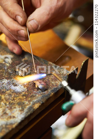 Hands, jewelry and closeup of torch metal for creative art.manufacturing, steel process in workshop. Fingers, expert and equipment for silver heating or handmade business, flame craft or iron design Hands, jewelry and closeup of torch metal for creative art.manufacturing, steel process in workshop. Fingers, expert and equipment for silver heating or handmade business, flame craft or iron design 114322270