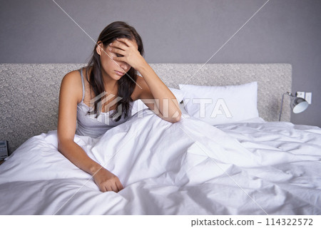 Getting a slow start this morning. an attractive young woman sitting on her bed looking unhappy. Getting a slow start this morning. an attractive young woman sitting on her bed looking unhappy. 114322572