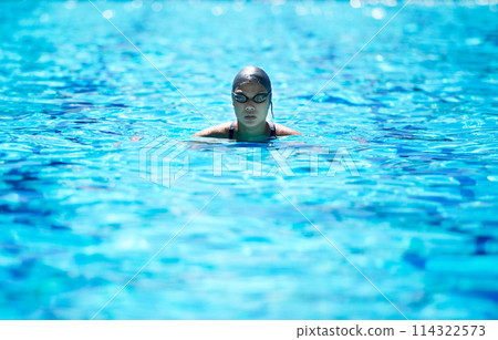 Face, swimming and pool with a sports woman for training, cardio workout or exercise for fitness. Female athlete person or professional swimmer in clear blue water for competition in goggles 114322573