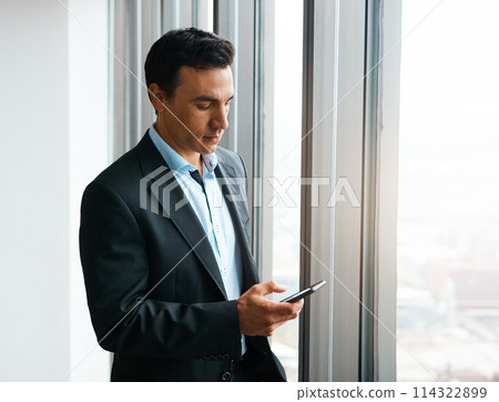 Looks like I have a meeting in an hour...a well-dressed businessman using his cellphone at the office. Looks like I have a meeting in an hour...a well-dressed businessman using his cellphone at the office. 114322899