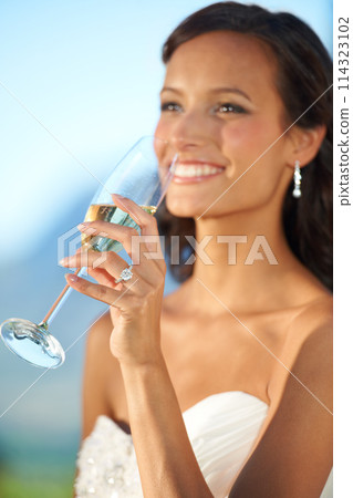 Woman, bride and smile or drinking champagne, event and celebration for marriage. Happy female person, party and relaxing at outdoor ceremony, confident and excited in nature, fashion and wedding 114323102