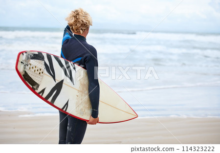 Surfer, man and back view on beach with surfboard, vacation and adventure for fitness and travel. Ocean, waves for surfing and seaside holiday in Hawaii, nature and tourism with extreme sports 114323222