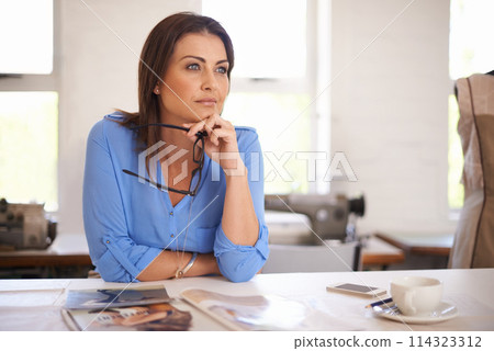 Businesswoman, entrepreneur and thinking at desk in office, workspace or work environment for creative career. Female person, fashion designer or tailor with idea for clothing range, style or designs 114323312