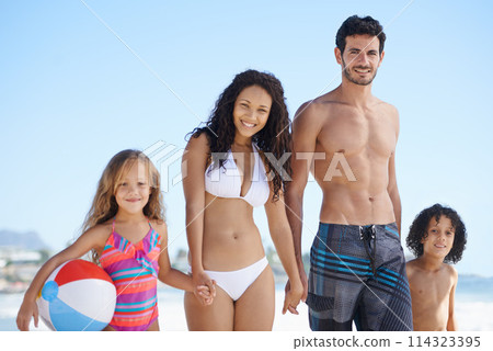 Happy family, portrait and holding hands on beach for bonding, vacation or outdoor holiday weekend together. Father, mother and children smile with ball for summer break by the ocean coast in nature 114323395