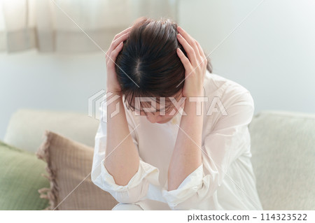 女人在客廳抱著頭，頭痛，感覺不舒服 114323522