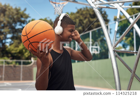 Getting into the mood for a good game. a sporty young man listening to music while playing basketball on a sports court. Getting into the mood for a good game. a sporty young man listening to music while playing basketball on a sports court. 114325218