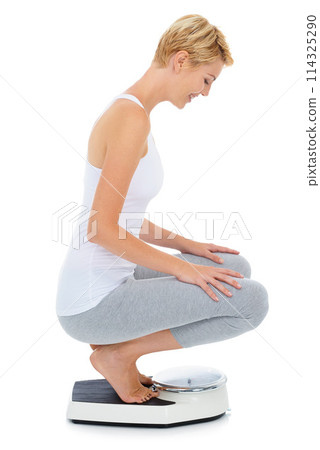 Woman, happy and scale in studio for weight loss, healthcare and wellness for vitality. Female person, diet and check calories for slim body for self care, achievement and sit with white background 114325290
