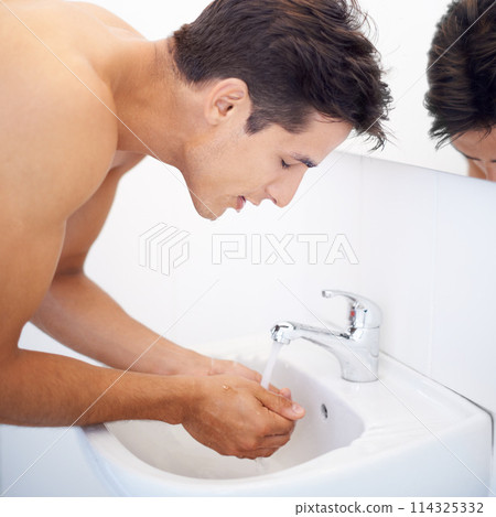 Man, washing face and water for hygiene in mirror, clean and cosmetics or skincare. Male person, bathroom and wellness in morning routine, reflection and grooming or self care and basin at home Man, washing face and water for hygiene in mirror, clean and cosmetics or skincare. Male person, bathroom and wellness in morning routine, reflection and grooming or self care and basin at home 114325332