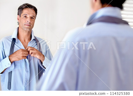 Portrait, mature businessman mirror and getting ready for work or executive board. Shirt, fashion and corporate employee confident looking at his reflection whilst dressed in the morning in bedroom Portrait, mature businessman mirror and getting ready for work or executive board. Shirt, fashion and corporate employee confident looking at his reflection whilst dressed in the morning in bedroom 114325380