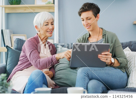 Can we watch this later. an attractive young woman sitting with her happy senior mother and using a tablet while at home. 114325456