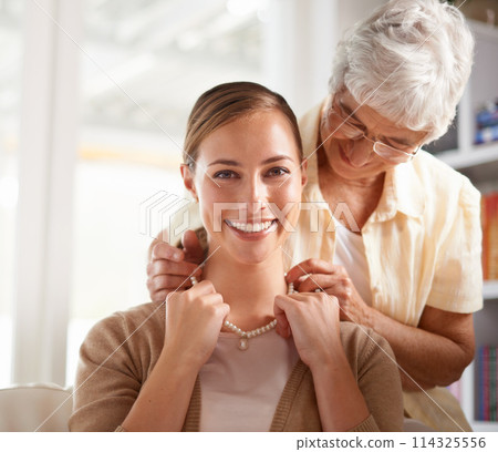 Necklace, jewellery and portrait of mother and woman for present, gift and surprise in living room. Family, pearls and happy daughter with senior mom on sofa for celebration, birthday and bonding 114325556