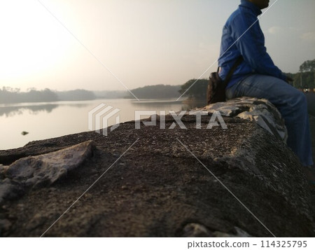 A man who is enjoying the natural scenery with an eye on the future 114325795