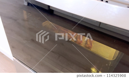 Crispy bacon strips bake evenly on a parchment-lined tray inside an oven, showcasing a clean and efficient method for achieving perfectly cooked bacon with minimal mess. Crispy bacon strips bake evenly on a parchment-lined tray inside an oven, showcasing a clean and efficient method for achieving perfectly cooked bacon with minimal mess. 114325908