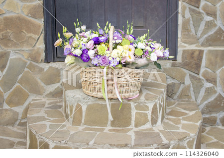 a basket of flowers on the steps in front of the front door a basket of flowers on the steps in front of the front door 114326040