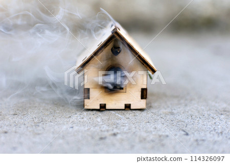 a toy wooden house is smoking. fire, disaster a toy wooden house is smoking. fire, disaster 114326097