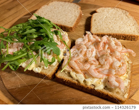 Sandwiches with shrimp, egg and arugula salad on wooden background 114326179