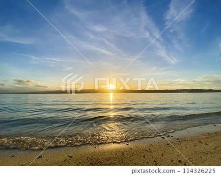 Beautiful sunrise over the sea with waves and sand, blue sky 114326225