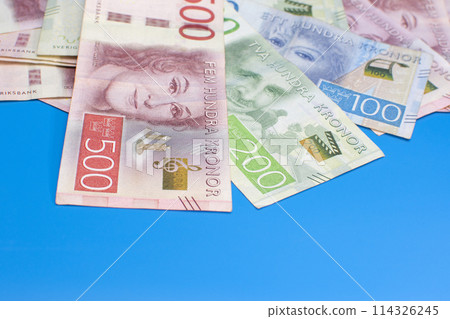 Swedish krona banknotes of different denominations on a blue background 114326245