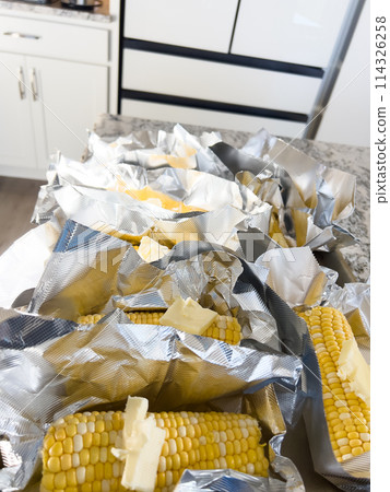 This image showcases fresh corn on the cob, neatly arranged in vacuum-sealed plastic packaging to preserve its freshness and flavor, ready for distribution or sale. This image showcases fresh corn on the cob, neatly arranged in vacuum-sealed plastic packaging to preserve its freshness and flavor, ready for distribution or sale. 114326258
