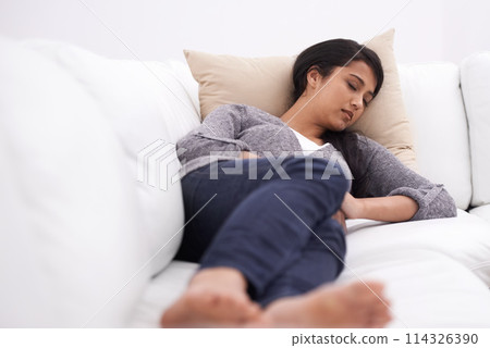 Sleeping, woman and sofa in the morning with rest, fatigue and nap in a home. Tired female person, couch and relax in a lounge with dreaming, house and living room with peace, sleepy and calm 114326390