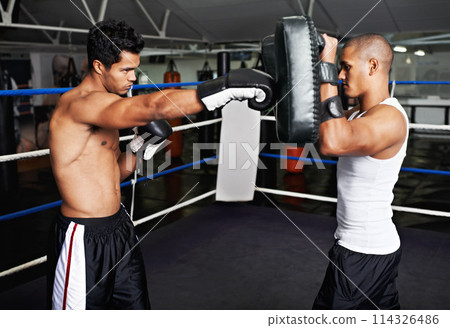 Boxer, man and instructor in boxing ring for training, workout and punching bag for performance with fight or fitness. Professional, athlete or exercise for competition, match or sport with wellness Boxer, man and instructor in boxing ring for training, workout and punching bag for performance with fight or fitness. Professional, athlete or exercise for competition, match or sport with wellness 114326486