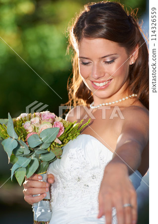 Happy woman, bride and bouquet of flowers at wedding for marriage, love or commitment at outdoor ceremony. Married female person smile with floral roses in beauty or dress for celebration in nature 114326559