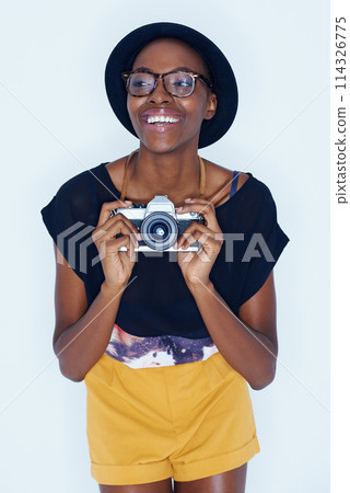 Black woman, photographer and happiness in studio with camera, creativity and talent in media in artist career. Young person, positive and vision for photoshoot and focus lens by white background 114326775